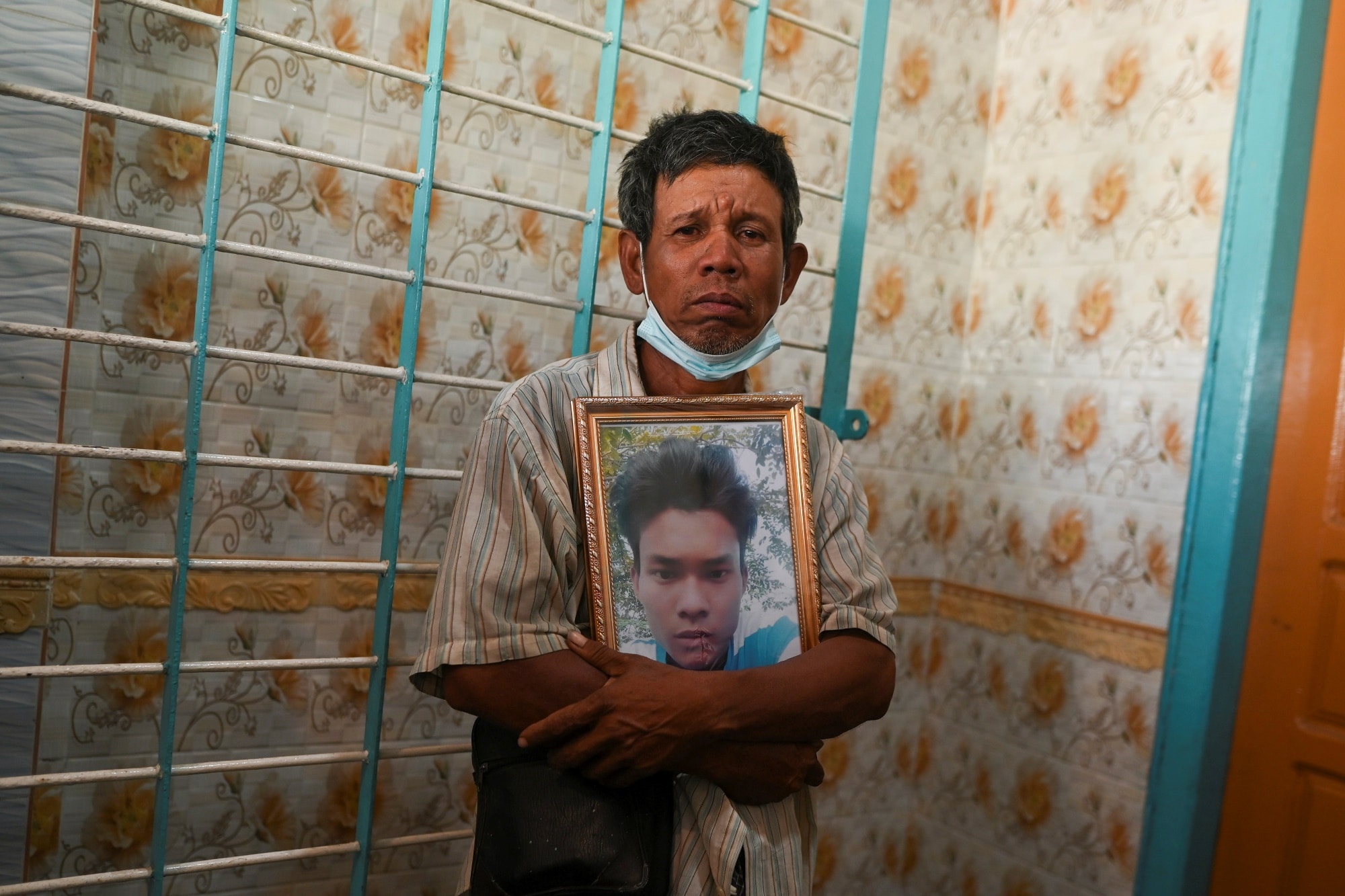Muž s fotkou jedné ze zastřelených obětí při protestech v Myanmaru