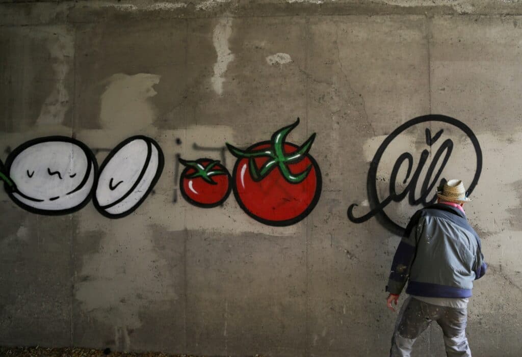 Na překrytí rasistických graffiti používá barvy ve spreji