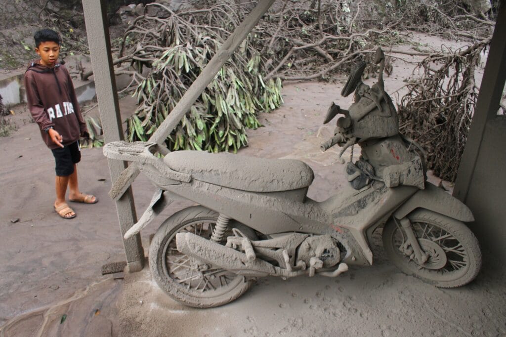 Motocykl pokrytý sopečným popelem ve vesnici Supiturang