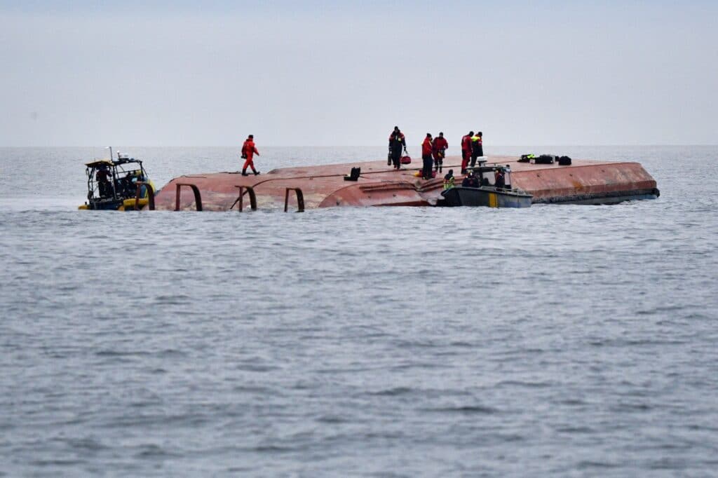 Záchranáři na převrácené dánské nákladní lodi Karin Hoej