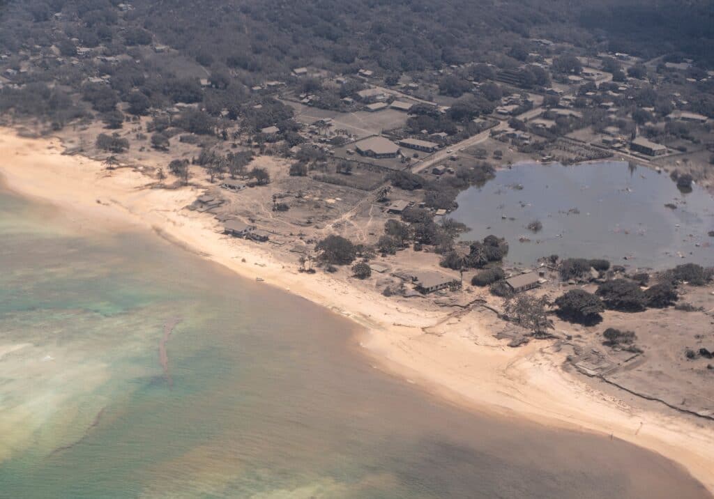 Domy a stromy na ostrově Nomuka pokryté sopečným popelem, Tonga