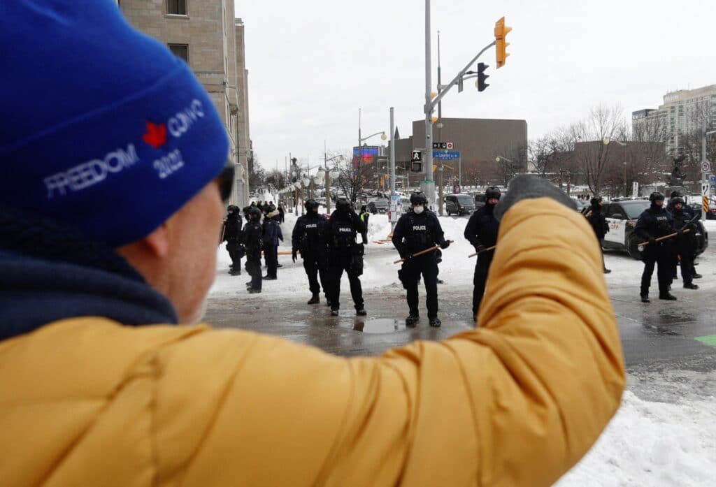 Osoba podporující demonstranty z Konvoje svobody křičí na kanadské policisty