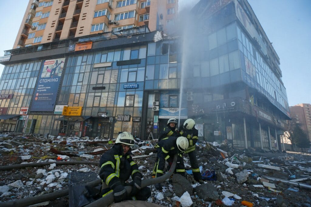 Hasiči likvidují požár v domě poškozeném ostřelováním v Kyjevě
