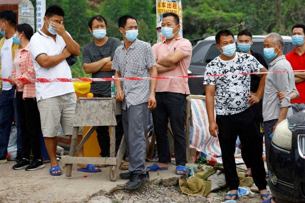 Lidé u vjezdu do vesnice Lu poblíž místa, kde se zřítil Boeing 737-800