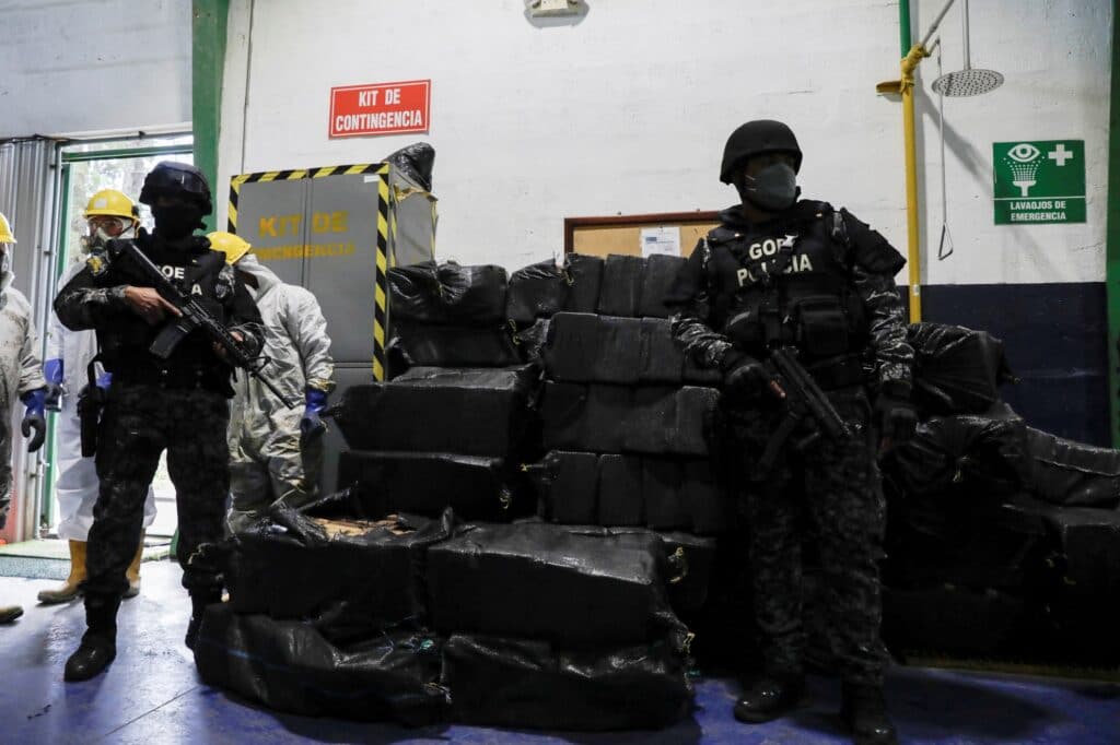 Policisté hlídají u pytlů, které obsahují balíčky kokainu
