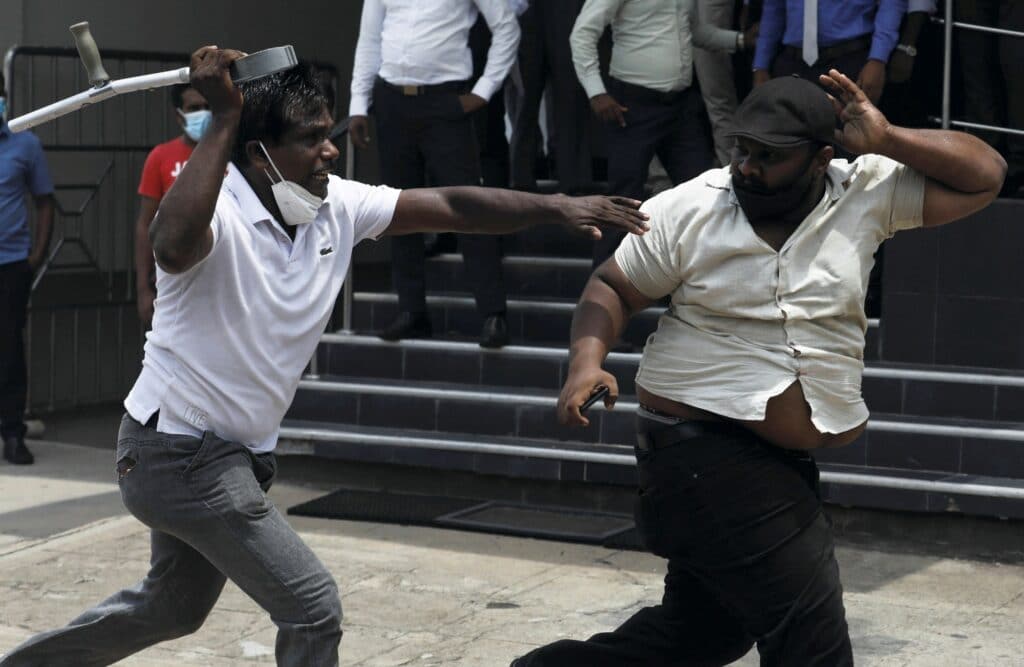 Stoupenec srílanské vládnoucí strany běží za protivládním demonstrantem, Kolombo