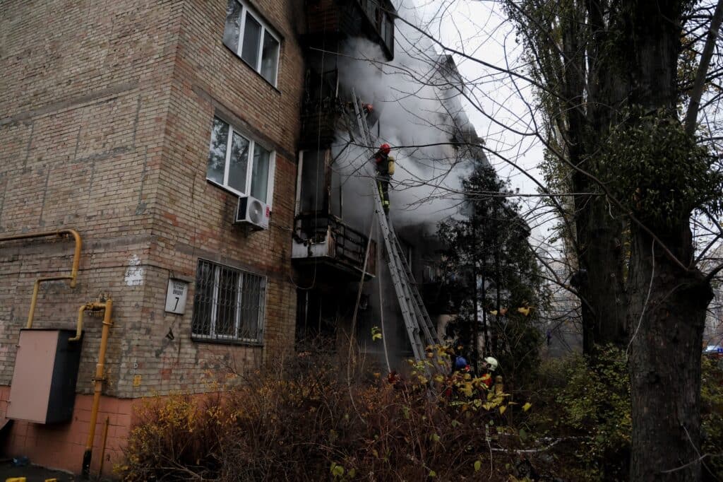 Hasiči pracují na uhašení požáru obytného domu zasaženého ruským raketovým útokem