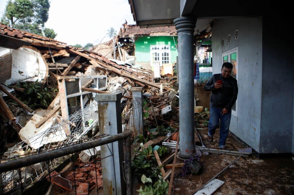 Muž kontroluje svůj dům, který byl poškozen při zemětřesení