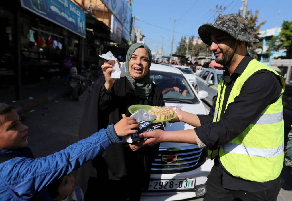 Palestinec kolemjdoucím u místa exploze rozdává sladkosti