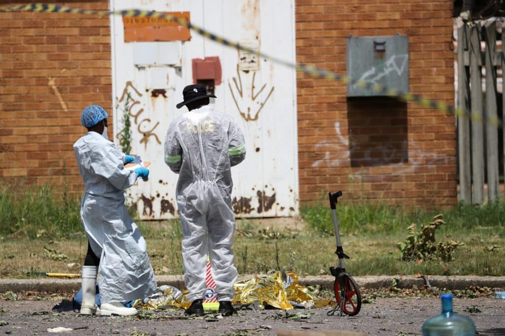 Forenzní patologové shromažďují lidské ostatky na místě exploze