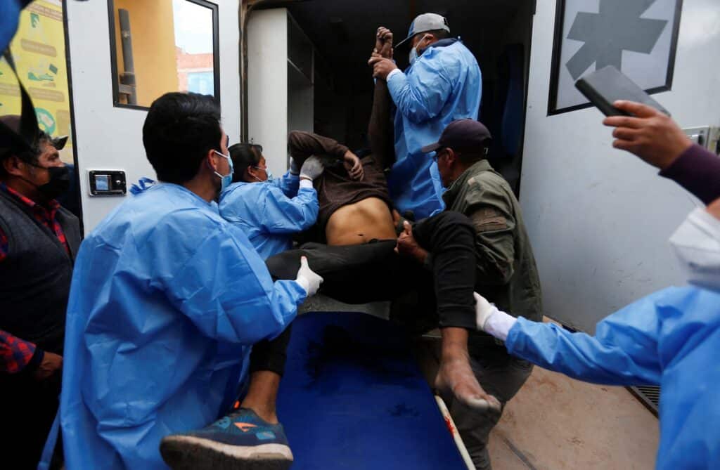 Zdravotnický personál pomáhá naložit demonstranta do sanitky zraněného během střetu s bezpečnostními silami