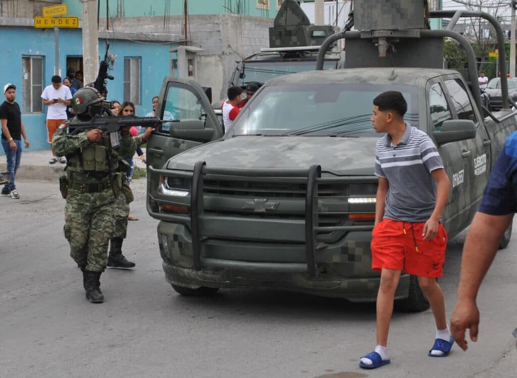 Mexický voják míří na muže ve městě Nuevo Laredo