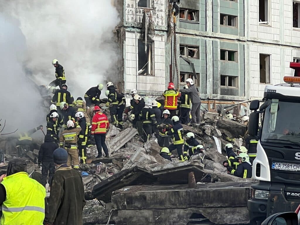 Hasiči a záchranáři u poškozené budovy po ruském raketovém útoku, Umaň, 28. dubna 2023