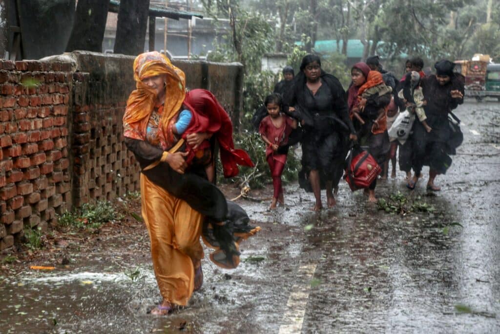 Lidé se přesouvají ze svých domovů do krytu, Bangladéš