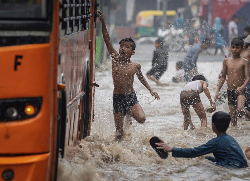 Děti na zaplavené silnici po vydatných deštích, Nové Dillí