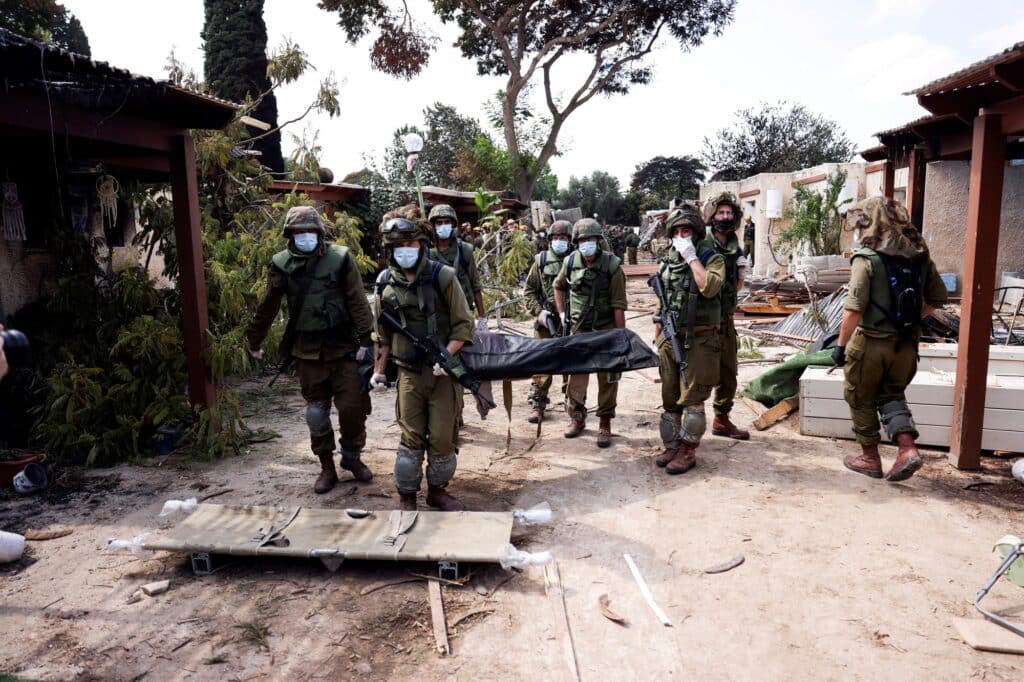 Izraelští vojáci nesou tělo oběti útoku ozbrojenců z Gazy, jižní Izrael, 10. října 2023